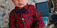 Rafaël participe au concours pour gagner de l'argent avec cette photo : toddler, child, boy, plaid_shirt, bow_tie, indoor, glass_table, chair, home_interior, patterned_wall, curious, sitting, casual_clothing, young_child, face, hands, floor_tiles, cozy, decor, casual