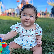 Sienna joined the competition — help win amazing prizes! baby, blue_eyes, bow, child, curly_hair, cute, daytime, dress, fairground, ferris_wheel, festival, fun, grass, happy, outdoor, people, playful, sitting, smiling, toy
