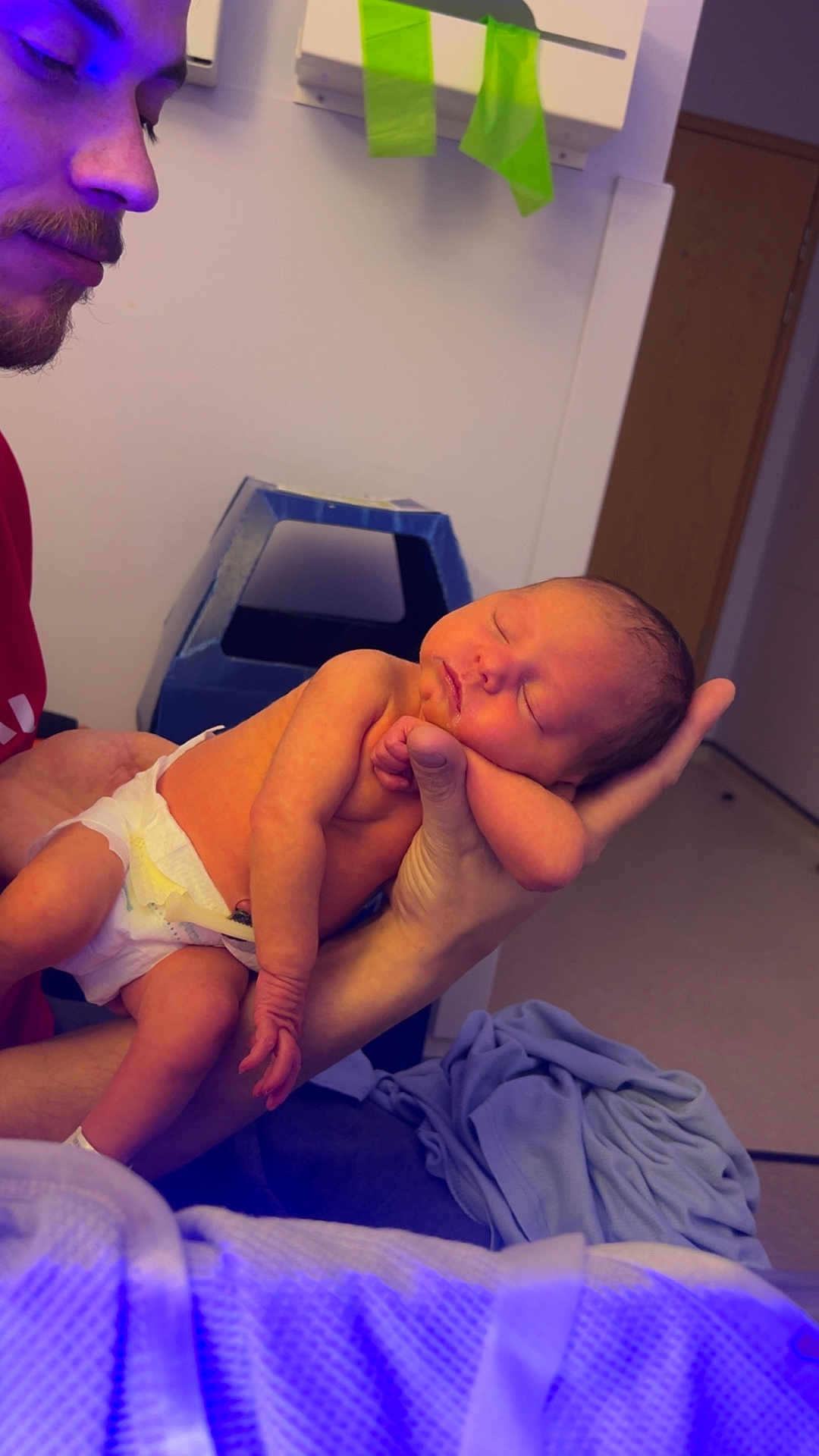 Arabella is registered to the contest to win money with this photo: newborn, baby, man, holding, sleeping, diaper, hand, face, indoor, blanket, bed, person, skin, closeup, parent, care, rest, peaceful, gentle, family