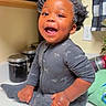 Javonte is registered to the contest to win money with this photo: toddler, child, smiling, happy, kitchen, countertop, onesie, hair, powder, joyful, indoor, cabinet, jars, curtain, power_outlet, clothing, person, baby, sitting, cute