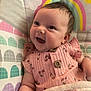 baby, smiling, infant, pink_clothing, cherry_pattern, blanket, rainbow, cloud, happy, cute, child, portrait, closeup, face, soft_texture, indoor, young, person, cheerful, sleeping_bag