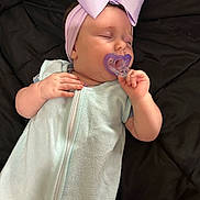Ember is registered to the contest to win money with this photo: baby, sleeping, pacifier, headband, bow, light_blue, sleeper, infant, hand, face, closed_eyes, blanket, resting, cozy, cute, child, indoor, soft, peaceful, portrait