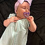 baby, sleeping, pacifier, headband, bow, light_blue, sleeper, infant, hand, face, closed_eyes, blanket, resting, cozy, cute, child, indoor, soft, peaceful, portrait