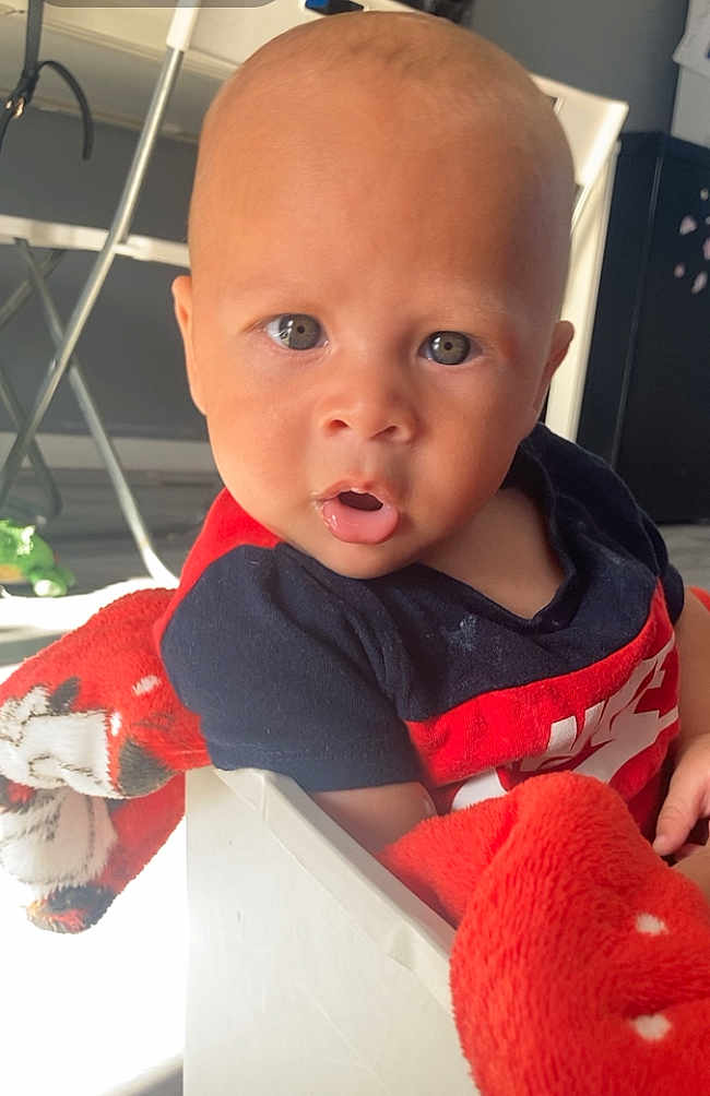 Elijah joined the competition — help win amazing prizes! baby, child, indoor, blanket, box, curious, face, person, red, shirt, light, furniture, floor, expression, head, skin, sitting, young, infant, cute