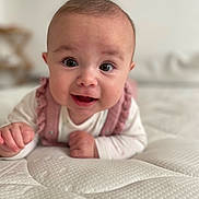 Octavia a rejoint le concours — aidez-le/la à gagner de superbes lots ! baby, infant, smiling, cute, face, eyes, pink_clothing, white_mattress, texture, lying_down, portrait, child, young, happy, indoors, soft_light, hands, head, ruffles, closeup