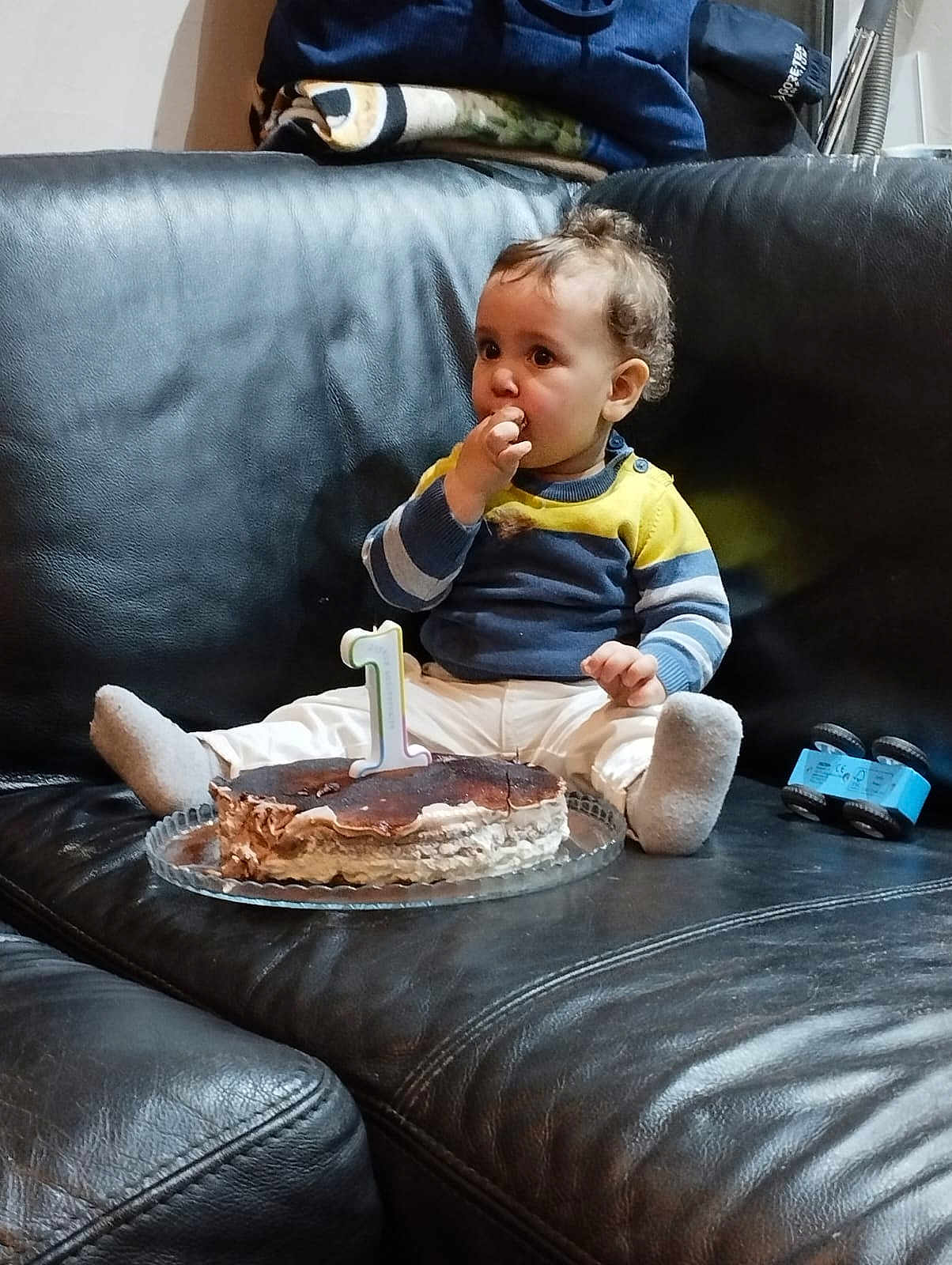 Yaraun participe au concours pour gagner de l'argent avec cette photo : baby, child, cake, birthday, couch, leather, sweater, pants, toy, first_birthday, celebration, food, plate, indoor, curious, sitting, sock, hair, face, hands