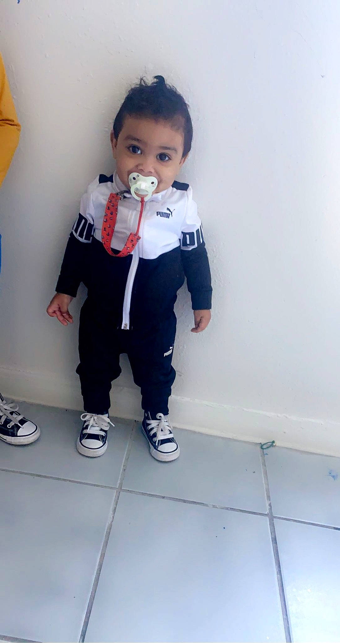 Kenai is registered to the contest to win money with this photo: baby_toddler_clothing, eye, face, floor, flooring, footwear, gesture, hair, happy, head, knee, leg, neck, person, shoe, shoulder, sleeve, sneakers, t_shirt, thigh