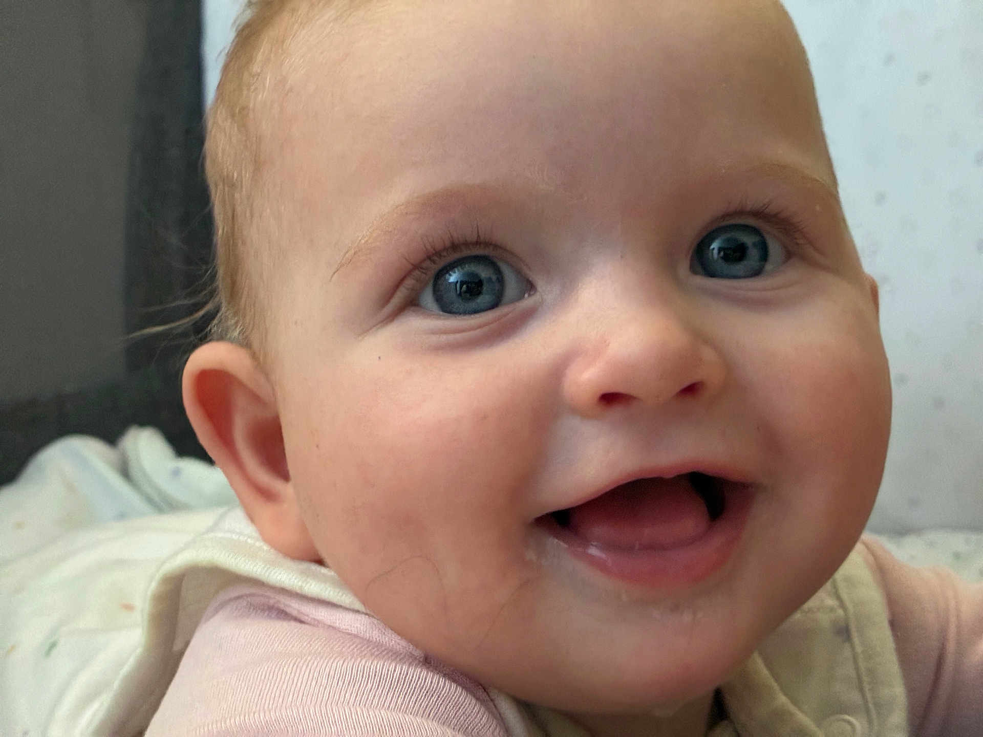 Tahlia is registered to the contest to win money with this photo: baby, child, face, smile, blue_eyes, closeup, infant, happy, skin, cheeks, mouth, tongue, clothing, person, cute, expression, young_child, indoors, portrait, head