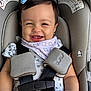 baby, baby_girl, bow, car_seat, child, closeup, clothing, comfort, cute, face, happiness, happy, head, indoors, infant, person, portrait, safety_harness, seatbelt, smiling