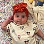 Luna is registered to the contest to win money with this photo: baby, infant, headwrap, orange, floral_blanket, plush_toy, disney_characters, cute, child, clothing, lying_down, soft_toys, portrait, indoors, smiling, toddler, pink, yellow, white, patterned_shirt