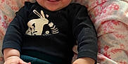 Luna is registered to the contest to win money with this photo: baby, black_shirt, blanket, bunny_design, child, clothing, comfort, cozy, cute, floral_pattern, flower, green_pants, hands, happy, headband, indoor, infant, portrait, smiling, soft