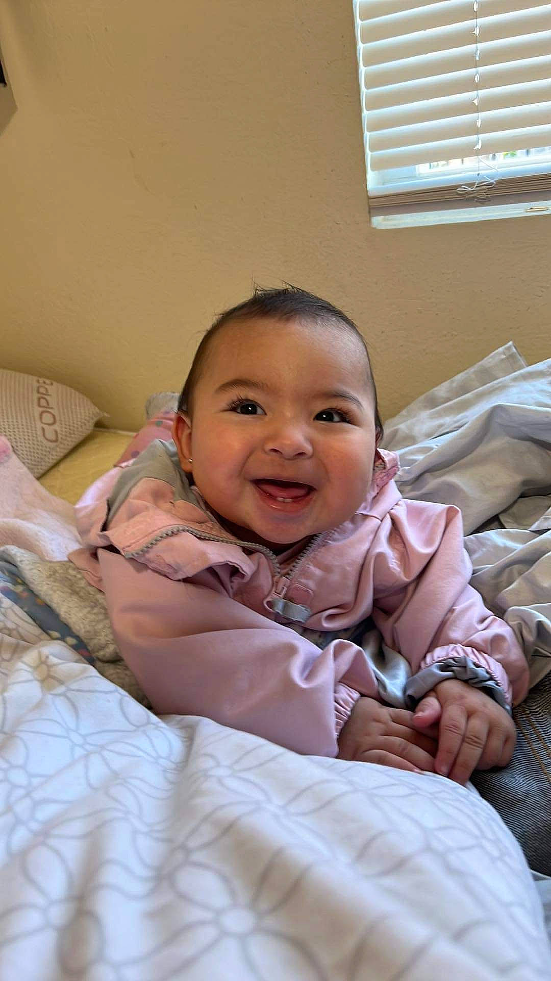 Celina is registered to the contest to win money with this photo: arm, baby, baby_toddler_clothing, cheek, child, comfort, event, eye, fun, gesture, happy, iris, linens, nose, person, sitting, skin, smile, toddler, window