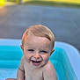 Gabin participe au concours pour gagner de l'argent avec cette photo : baby, bare_chest, blond_hair, child, closeup, cute, face, fun, happy, inflatable_pool, outdoor, playful, pool, sitting, skin, smiling, summer, sunlight, toddler, water