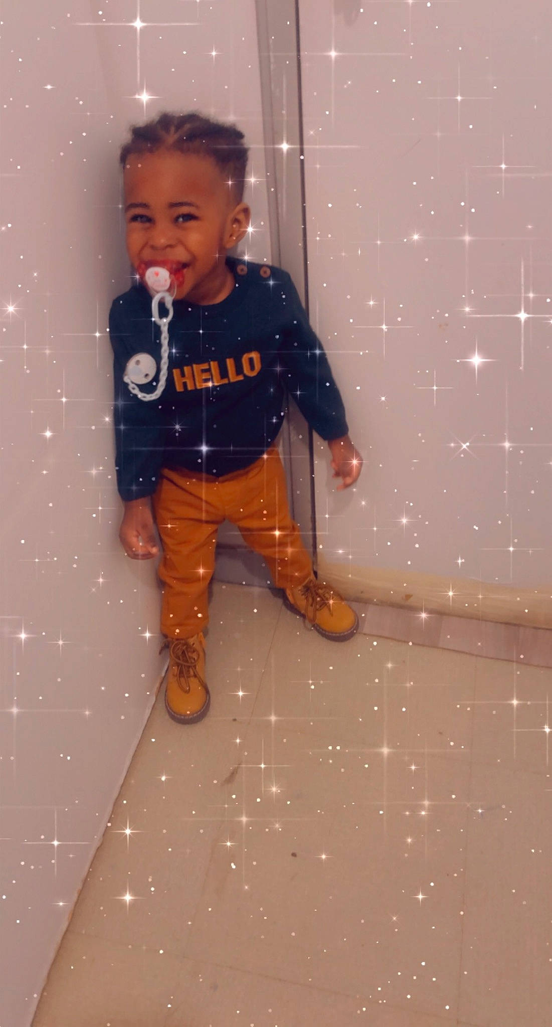 Alexis participe au concours pour gagner de l'argent avec cette photo : baby_toddler_clothing, boot, child, denim, electric_blue, fashion_design, flooring, foot, fun, hairstyle, head, knee, pattern, person, room, sandal, sleeve, smile, sock, t_shirt