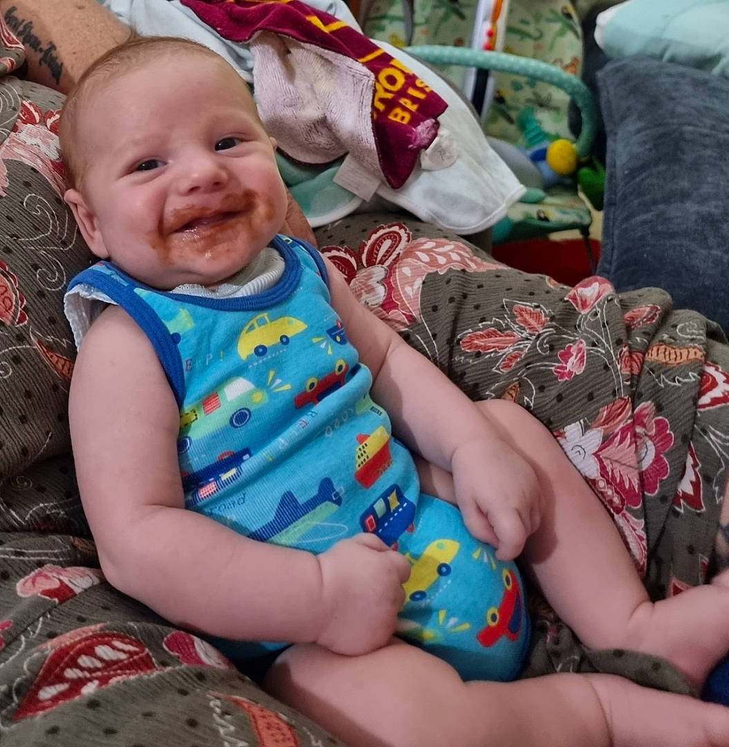 Kaiser is registered to the contest to win money with this photo: baby, baby_products, baby_toddler_clothing, child, comfort, event, face, fun, grass, happy, lap, leisure, pattern, person, sitting, skin, smile, t_shirt, textile, thigh