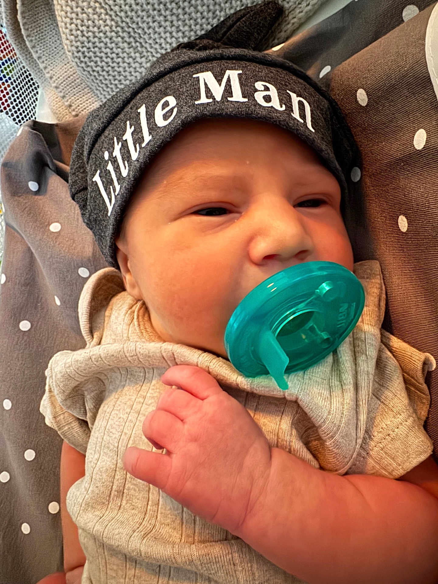 Jackson is registered to the contest to win money with this photo: baby, newborn, infant, pacifier, hat, clothing, hand, face, sleepy, blanket, polka_dots, cute, resting, indoors, portrait, child, soft_lighting, close_up, baby_boy, cozy