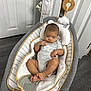 Zaire joined the competition — help win amazing prizes! baby, infant, baby_rocker, onesie, gray_clothing, face, feet, hand, toy, cushion, striped_pattern, door, floor, wood_flooring, head, indoor, child, comfort, relaxing, person