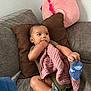 Zaire joined the competition — help win amazing prizes! baby, infant, couch, pillow, blanket, plush_toy, socks, hand, foot, chewing, cozy, indoor, child, cute, curious, relaxed, living_room, soft_toys, clothing, skin