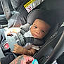 baby, car_seat, infant, pacifier, hand, tattoo, seatbelt, car_interior, child, safety_harness, person, clothing, black_clothing, white_shirt, closeup, portrait, looking, indoor, young_child, seat