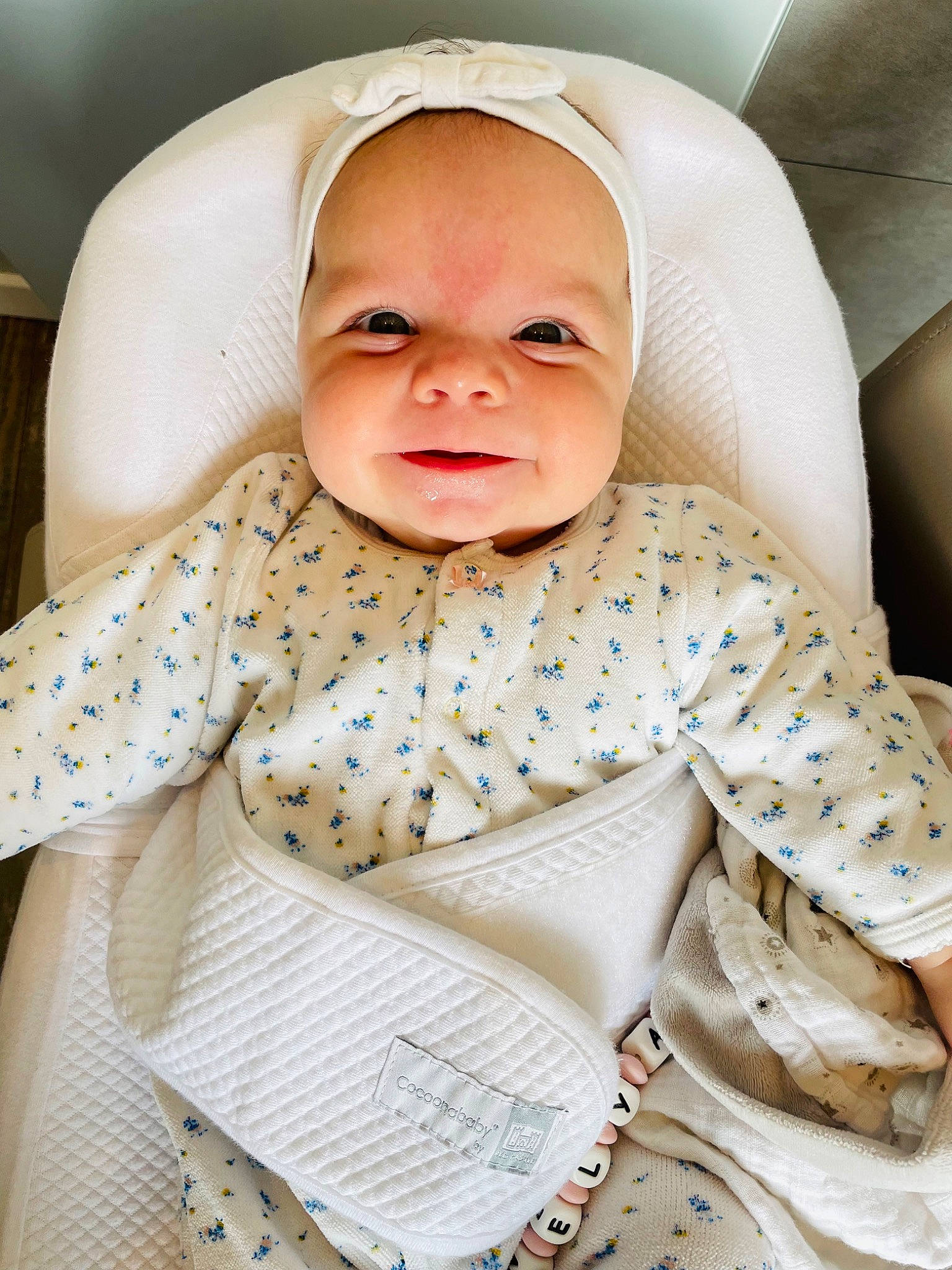 Nelya participe au concours pour gagner de l'argent avec cette photo : baby, baby_products, baby_safety, baby_toddler_clothing, cheek, child, collar, comfort, eye, happy, linens, nose, outerwear, person, portrait_photography, room, sitting, skin, sleeve, smile