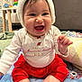 baby, child, smiling, happy, sitting, hat, clothing, red_skirt, white_shirt, blanket, indoors, face, cute, infant, festive, holiday, knitted_hat, expression, person, toddler