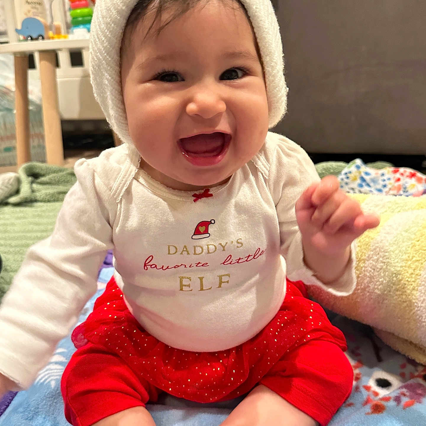 Natalia joined the competition — help win amazing prizes! baby, blanket, child, clothing, cute, expression, face, festive, happy, hat, holiday, indoors, infant, knitted_hat, person, red_skirt, sitting, smiling, toddler, white_shirt