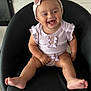 Naiomi is registered to the contest to win money with this photo: baby, child, smile, headband, bow, black_chair, happy, cute, infant, sitting, indoors, clothing, legs, toes, person, portrait, joyful, expression, skin, young