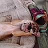 dog, puppy, sleeping, bed, blanket, paw, face_covering, shoe, sneaker, colorful, cozy, resting, indoor, cute, pet, fur, pink, purple, green, soft