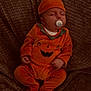 baby, infant, sleeping, pacifier, orange_clothing, pumpkin_costume, hat, blanket, texture, cute, child, cozy, rest, comfort, portrait, indoor, soft, hands, feet, face