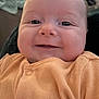 baby, infant, smiling, face, orange_clothing, cute, indoors, portrait, child, happy, skin, head, eyes, mouth, buttoned_clothing, blanket, door, human, closeup, expression