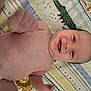 baby, smiling, infant, bare_chest, lying_down, blanket, patterned_blanket, animal_pattern, geometric_pattern, happy, cute, child, skin, head, face, hand, diaper, playful, indoors, portrait