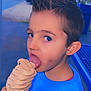 blue_sweater, boy, casual, child, cute, daylight, dessert, face, food, hand, ice_cream, outdoor, portrait, smudge, soft_serve, spiderman, summer, table, tongue, tree