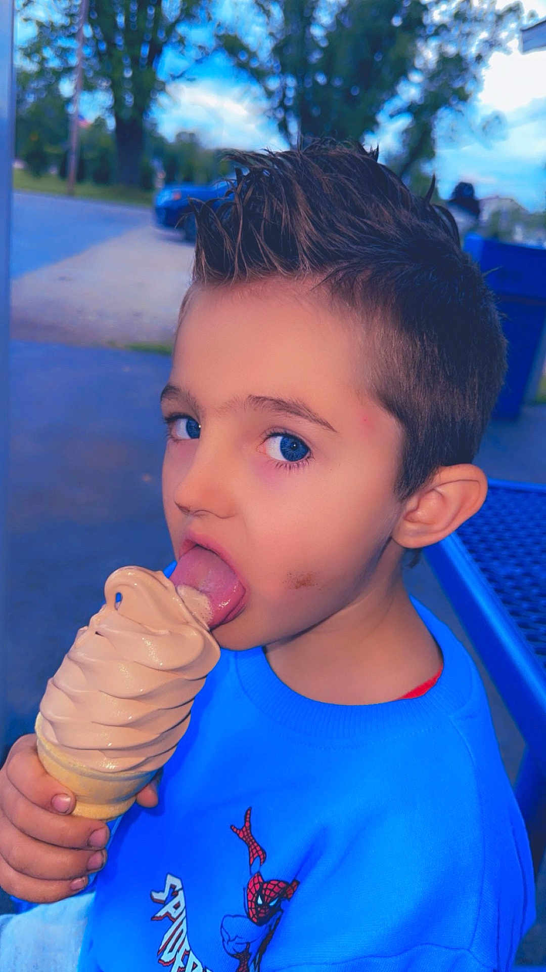 Shane joined the competition — help win amazing prizes! child, boy, ice_cream, soft_serve, outdoor, blue_sweater, spiderman, food, dessert, tongue, face, smudge, hand, table, tree, daylight, casual, cute, portrait, summer