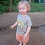 child, toddler, barefoot, curly_hair, sand, mud, outdoor, trees, greenery, tshirt, shorts, play, happy, smiling, nature, water, summer, casual_clothing, dirt, person