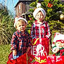 Braidon joined the competition — help win amazing prizes! child, children, christmas, holiday, santa_hat, gift_bag, plaid_shirt, outdoor, tree, grass, sunny, decoration, festive, smiling, baby, holiday_season, present, celebration, family, fun