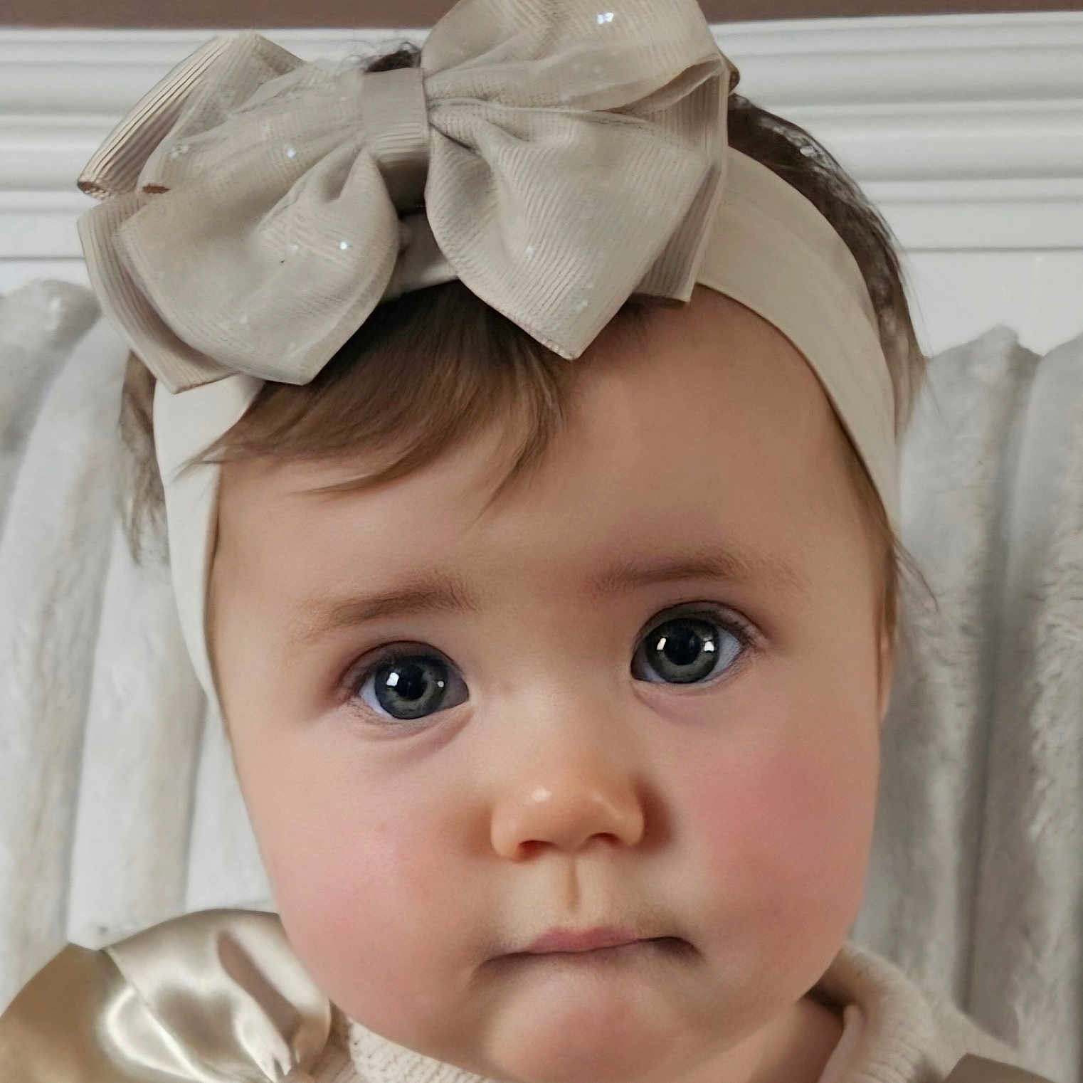 Maddison is registered to the contest to win money with this photo: adorable, apparel, baby, baby_girl, bow, child, closeup, clothing, cream_color, cute, expressionless, face, headband, headwear, indoors, infant, person, portrait, soft_lighting, young_child