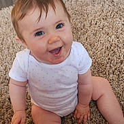 Maddison joined the competition — help win amazing prizes! baby, child, smiling, sitting, carpet, onesie, pink, unicorn, backpack, happy, cute, indoor, floor, hand, foot, person, infant, playful, bright_eyes, expression