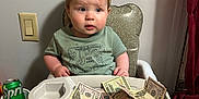 Luca joined the competition — help win amazing prizes! baby, toddler, high_chair, money, cash, can, sprite, shirt, cool_dude, foot, wood_floor, curtain, painting, wall, switch, cup_holder, face, person, indoor, expression