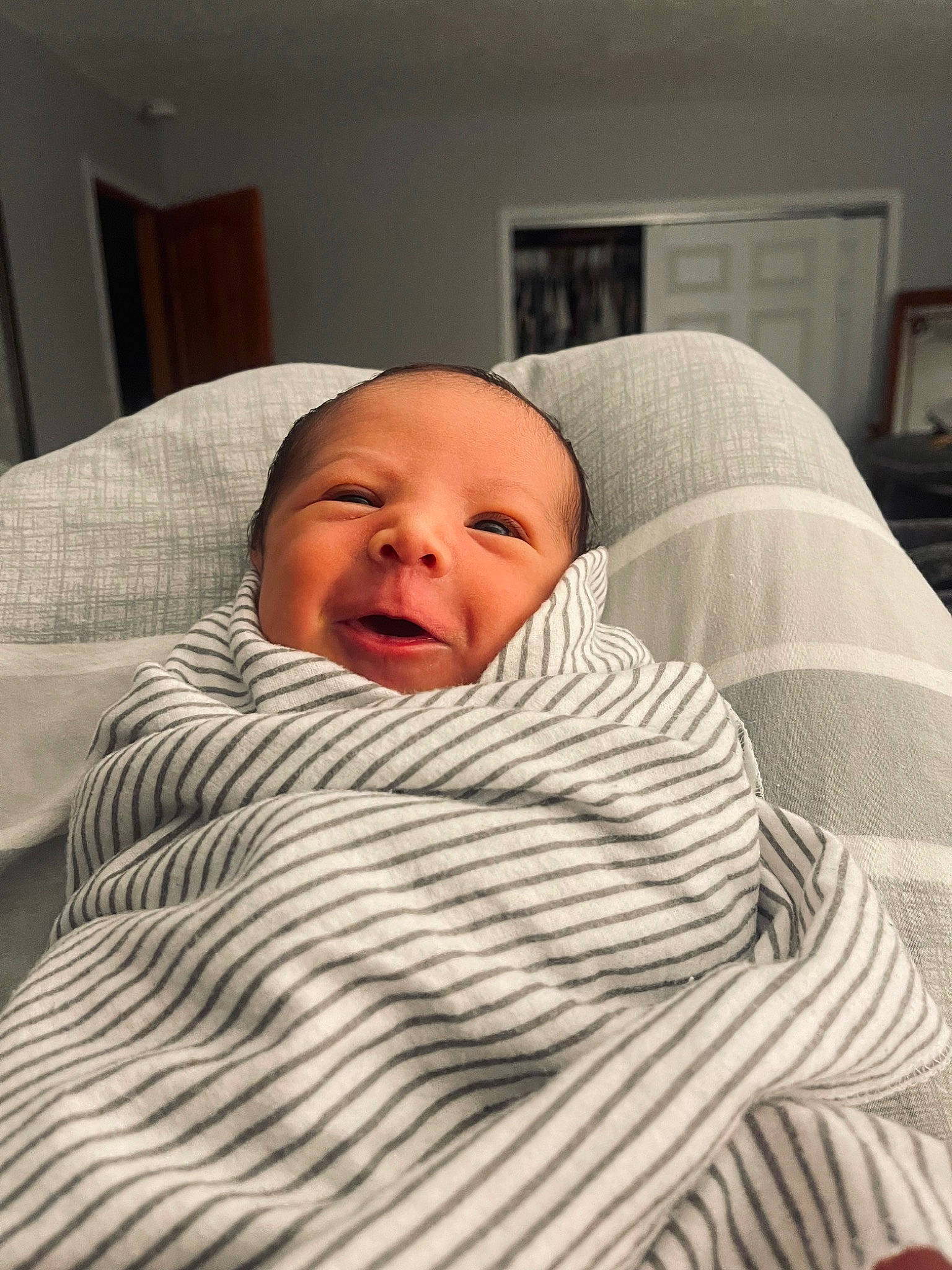 Lennon is registered to the contest to win money with this photo: baby, bed_sheet, bedding, bedtime, blanket, cheek, child, chin, comfort, event, eyebrow, flooring, linens, mouth, nose, person, picture_frame, room, sitting, sleep