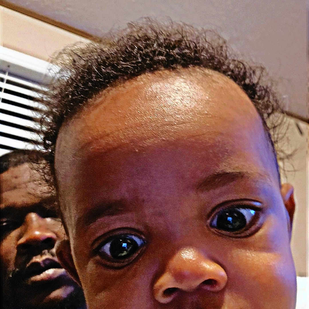 Markis is registered to the contest to win money with this photo: baby, drool, face, indoor, curious, closeup, child, person, adult, window, curtain, clothing, portrait, expression, head, skin, hair, room, background, lighting
