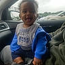 baby, child, smiling, indoor, car, blue_jacket, bib, person, seat, lap, window, parking_lot, clothing, hands, socks, happy, portrait, cute, young, people