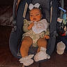 baby, car_seat, bow, bib, couch, leather, footwear, baby_clothing, infant, indoor, child, person, seat, toy, bottle, floor, relaxing, cute, portrait, small