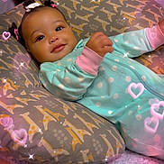 Iayla is registered to the contest to win money with this photo: baby, infant, pillow, giraffe_pattern, onesie, polka_dot, sleepwear, bed, blanket, hair_bows, smiling, face, cute, sparkles, hearts, indoors, cozy, child, resting, adorable