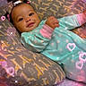 baby, infant, pillow, giraffe_pattern, onesie, polka_dot, sleepwear, bed, blanket, hair_bows, smiling, face, cute, sparkles, hearts, indoors, cozy, child, resting, adorable