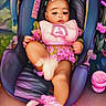 baby, child, infant, pink, bow, baby_carrier, clothing, pillow, floral_pattern, footwear, cushion, seat, indoors, person, cute, sleepy, soft_toys, colorful, portrait, baby_accessory