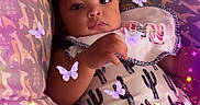 Iayla joined the competition — help win amazing prizes! baby, bib, cactus_print, child, clothing, cushion, cute, face, filter, giraffe_pattern, indoor, infant, lying_down, person, pillow, portrait, purple_butterflies, relaxing, soft_lighting, sparkles