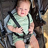 baby, child, infant, stroller, smiling, portrait, outdoor, sunlight, seated, harness, green_clothing, blue_eyes, blond_hair, face, hands, legs, road, pavement, safe, photography