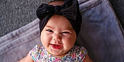 Ava Angeline joined the competition — help win amazing prizes! baby, child, smile, headband, bow, floral_dress, happy, face, portrait, infant, cute, laying_down, blanket, soft_texture, indoors, skin, person, young_child, cheerful, closeup
