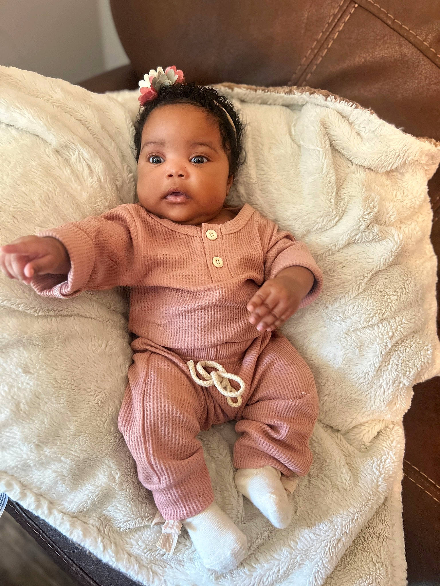 Taelyn is registered to the contest to win money with this photo: arm, baby, baby_toddler_clothing, cheek, chin, doll, eye, eyebrow, eyelash, fashion_accessory, fawn, head, iris, jewellery, linens, person, sitting, skin, sleeve, toy