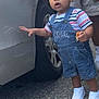 Jovani joined the competition — help win amazing prizes! toddler, child, denim_overalls, striped_shirt, white_sneakers, car, tire, hand, food, outdoor, curly_hair, person, walking, casual_clothing, pavement, exploration, support, baby, cute, daylight